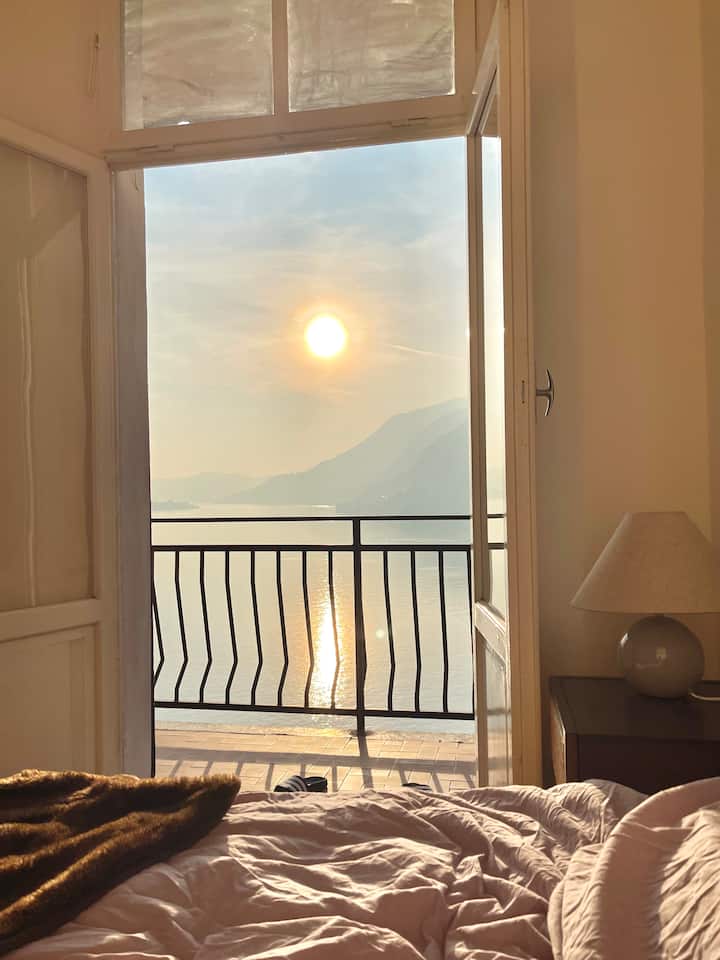 Bedroom at golden hour with the sun rising over the lake