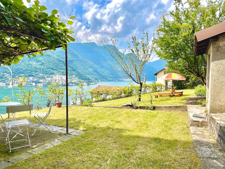 Wide garden lawn with loungers, pergola and lake view