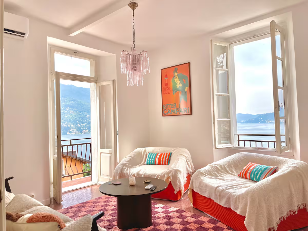 Living room with vintage pink chandelier, Campari poster and lake view